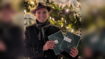 Leonhard Meixner, Volksmusikpfleger des Bezirks Oberbayern, mit den neuen Adventsliederheften. (Foto: Carola Pötz, Bezirk Oberbayern)