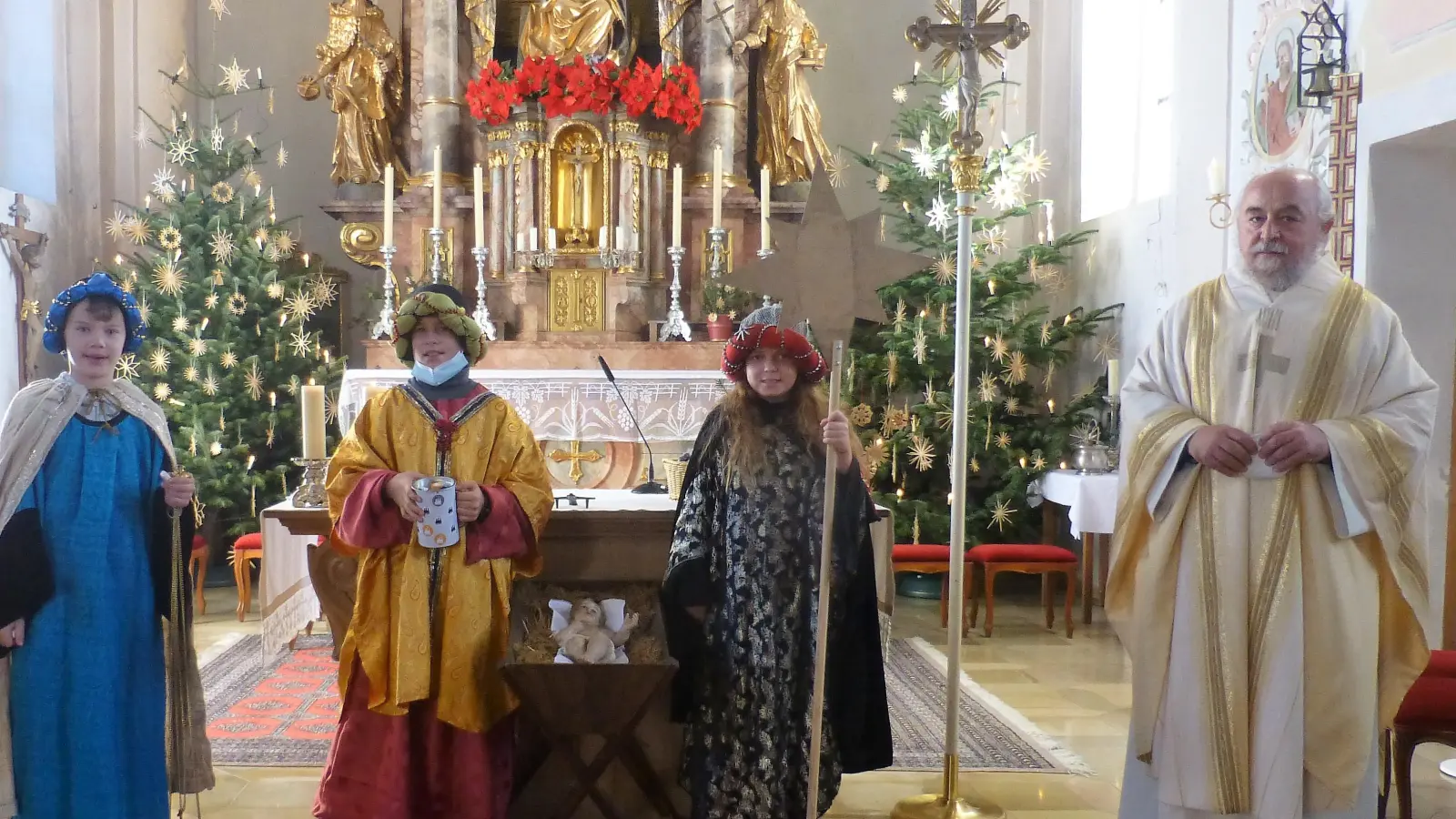 Eine Abordnung der „Drei heilige Könige“ Quirin Lohner, Emanuel Gnad und Sandra Hackl brachten ihre Segenswünsche den Kirchenbesuchern dar. Rechts im Bild der Geltinger Pfarrer Norbert Joschko. (Foto: Georg Rittler)