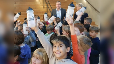 Die Erstklässler der Grundschule am SteinPark und Schulleiterin Sabine Jackermaier freuten sich über die geschenkten Trinkflaschen, die Dominik Schwegler, Geschäftsführer Freisinger Stadtwerke, mitgebracht hatte. (Foto: Freisinger Stadtwerke)