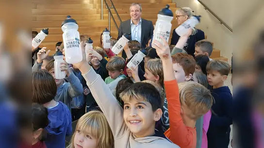 Die Erstklässler der Grundschule am SteinPark und Schulleiterin Sabine Jackermaier freuten sich über die geschenkten Trinkflaschen, die Dominik Schwegler, Geschäftsführer Freisinger Stadtwerke, mitgebracht hatte. (Foto: Freisinger Stadtwerke)