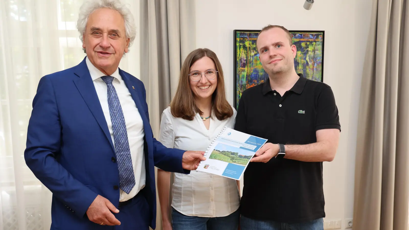 Landrat Helmut Petz (v. l.), Elisabeth Held, Leiterin der Geschäftsstelle Gutachterausschuss, und deren Mitarbeiter Christian Schmiedl präsentieren den ersten Grundstücksmarktbericht. (Foto: LRA Freising)