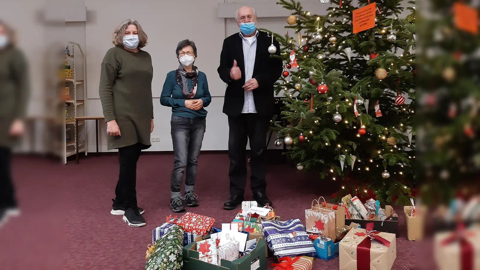 Ursula Schneider, Leiterin der Stadtbücherei Grafing, übergibt Weihnachtsgeschenke an die Vertreter der Grafinger Tafel, Ursula Rieder und Hans Rombeck (v. li.). (Foto: privat)
