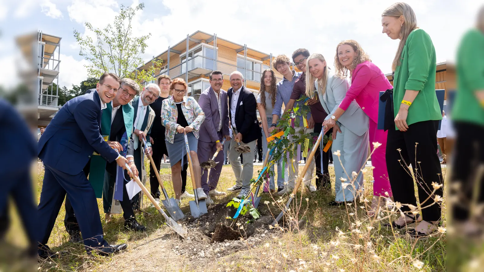 Ein neuer Baum bereichert künftig das Schulgelände. Gepflanzt wurde die Elsbeere gemeinsam von (v. l.) Landrat Stefan Frey, Pfarrer Ulrich Haberl, Pfarrer Simon Rapp, Projektleiter Tobias Pretscher, Petra Sedlacek, Kämmerer Stefan Pilgram, Bürgermeister ChristianSchiller, die Schülersprecher Elinor Petrick, Dominik Wolf und Amadeus Darchinger, Schulleiterin Dr. Eva Weingandt sowie ihre Stellvertreterinnen Claudia Wolff-Lieser und Alexandra Stumbaum. (Foto: LRA)