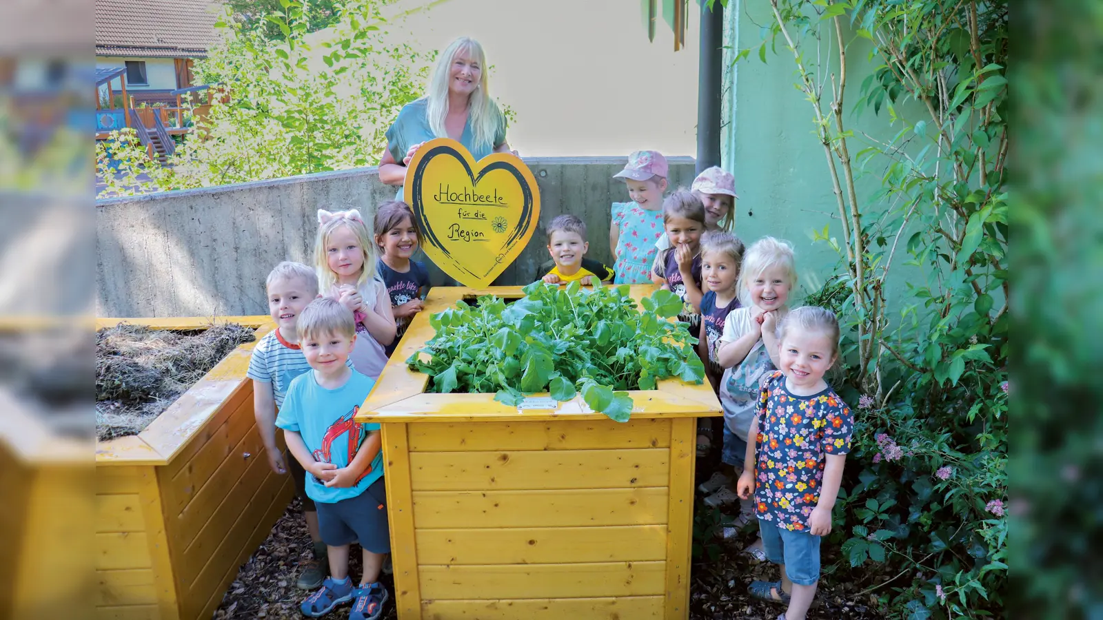 Die Kinder des Kindergartens St. Franziskus in Erding freuen sich riesig über die neuen Hochbeete. Elvira Brandl, Betreuung Privatkunden, mit Kindern des Kindergartens St. Franziskus.  (Foto: VR-Bank Erding)