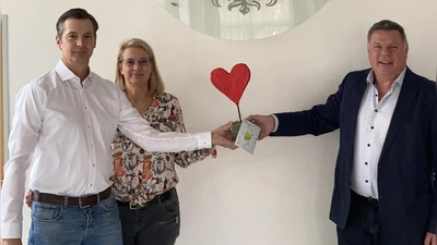 Bürgermeister Piet Mayr überreicht den Flutstein an das Ehepaar Meike und Stefan Winsel. (Foto: Gemeinde Zorneding)