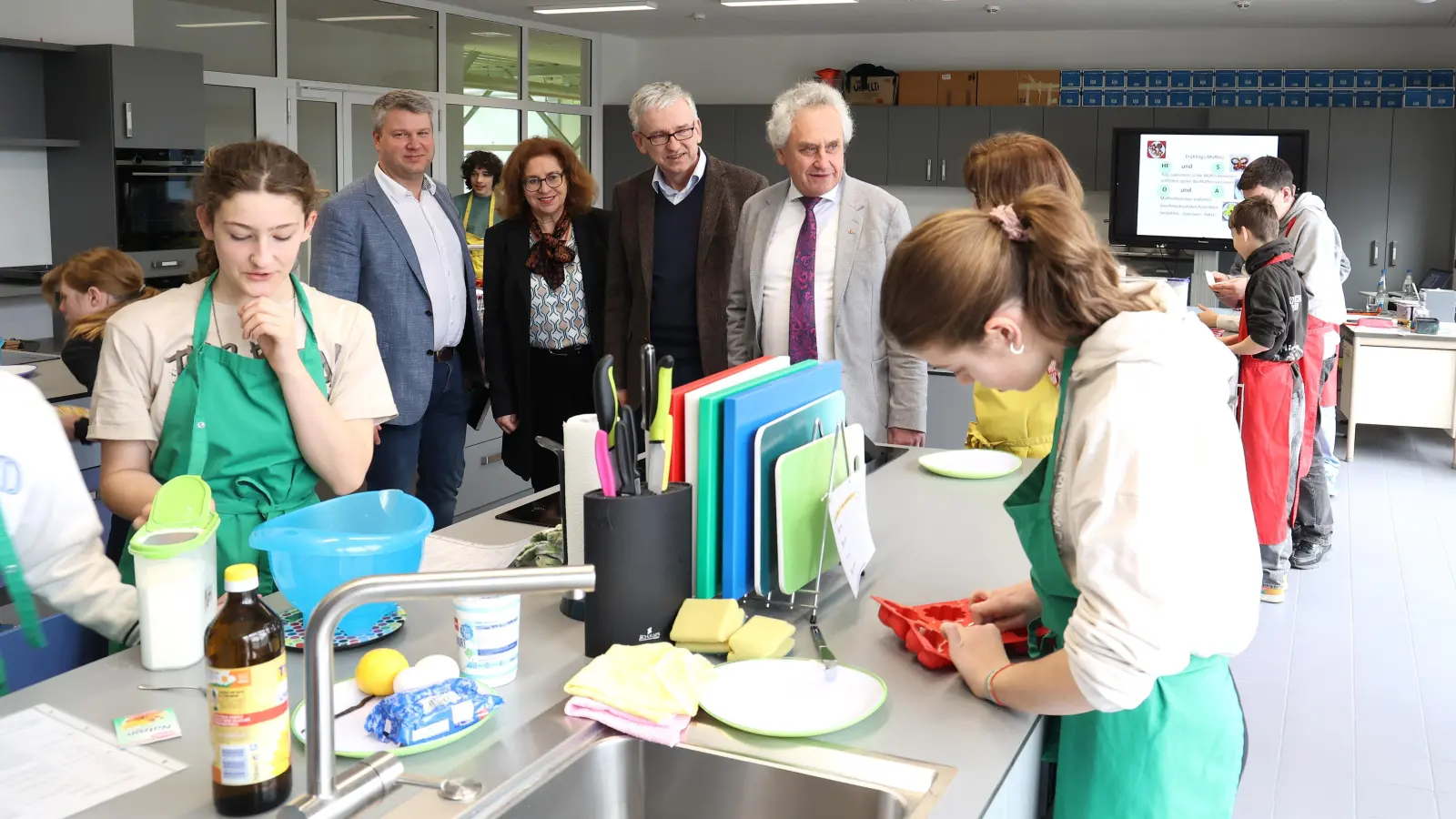 In der Lehrküche informierten sich Landrat Helmut Petz (v. re.), Schulleiter Bernd Friedrich, Architektin Michaela Bahner und Tassilo Brunner vom Landkreis-Hochbauamt über die ersten Erfahrungen mit den neuen Kochinseln. (Foto: Landratsamt Freising)