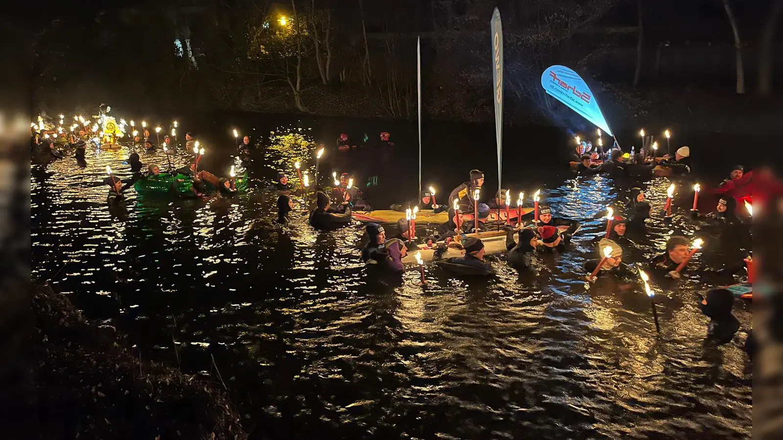 Mit Fackeln schwimmen die Teilnehmenden durch die Sempt. (Foto: jhö)