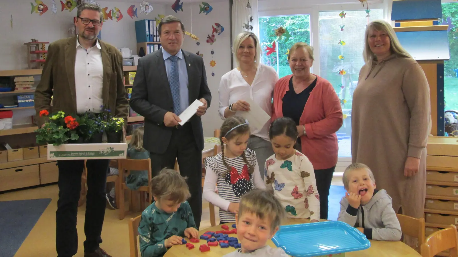 Amtsleiter Bartholomäus Aiglstorfer (li.) und OB Max Gotz beschenkten das Team des städtischen Kindergartens um die Leiterin Kathrin Veladzic (Mi.).  (Foto: Stadt Erding)