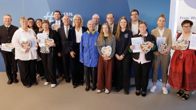 Bayerns Sozialministerin Ulrike Scharf mit den ehrenamtlich Engagierten, die den Ehrenamtsnachweis verliehen bekommen haben. (Foto: StMAS/Schäffler)