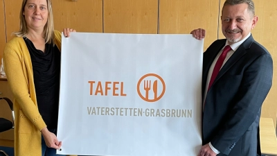 nbh-Mitarbeiterin Julia Haigis und Grasbrunns Bürgermeister Klaus Korneder freuen sich über das neue Banner "Tafel Vaterstetten-Grasbrunn". (Foto: Nachbarschaftshilfe)