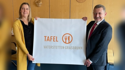 nbh-Mitarbeiterin Julia Haigis und Grasbrunns Bürgermeister Klaus Korneder freuen sich über das neue Banner "Tafel Vaterstetten-Grasbrunn". (Foto: Nachbarschaftshilfe)