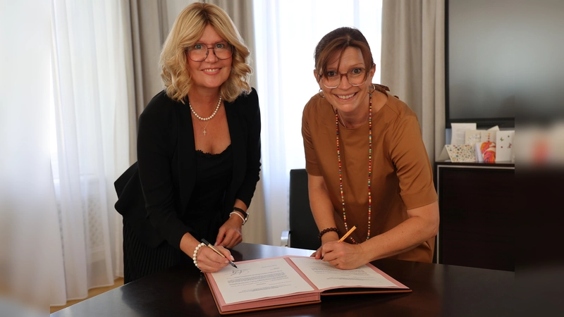Beim Unterzeichnen der Mandatsvereinbarung: Landrätin Susanne Hoyer und Freisings 3. Bürgermeisterin Monika Riesch (re.) (Foto: Landratsamt Freising)