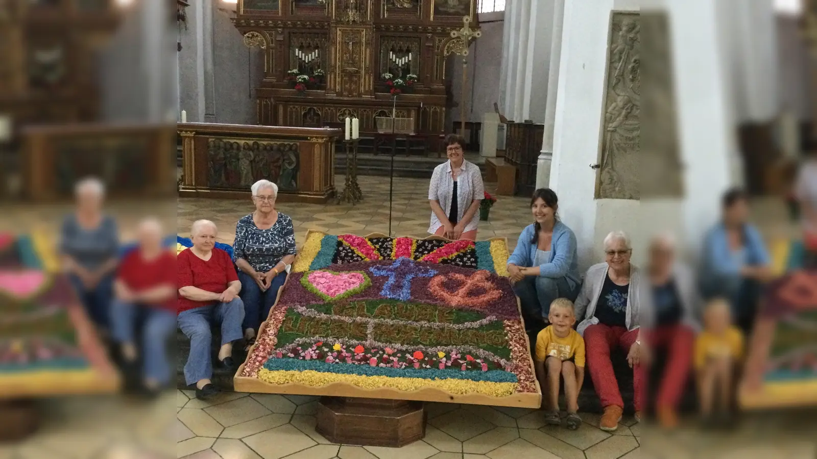 Die „Zupfer“ und „Leger“ der Kolpingsfamilie Erding mit ihrem fertigen Blumenteppich anlässlich der Fronleichnamsprozession. (Foto: Kolpingsfamilie Erding)