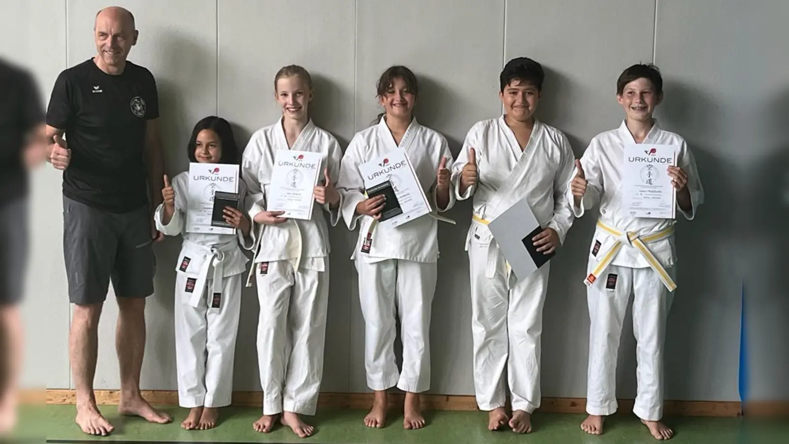 Prüfer und Erster Vorsitzender Christian Martin mit den bei der Gürtelprüfung erfolgreichen Kindern. (Foto: SC Eching)