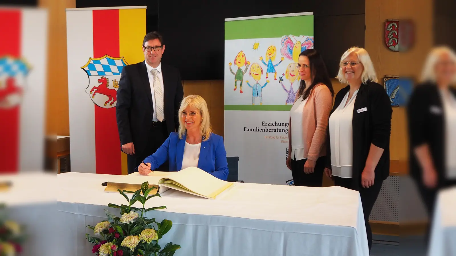 Landrat Martin Bayerstorfer, Familienministerin Ulrike Scharf, die zuständige Abteilungsleiterin Andrea Wolf und die Leiterin der Erziehungsberatungsstelle Sabine Wolf beim Eintrag ins Goldene Buch. (Foto: LRA Erding)