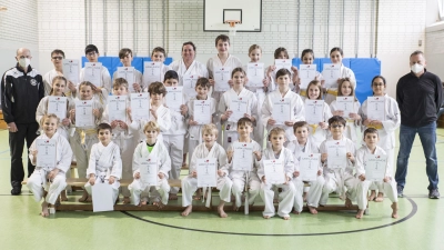 Endlich wieder Gürtelprüfung: 30 glückliche Karateka und ihre Prüfer Christian Martin (li.) und Dr. Dietmar Wagner (re.). (Foto: Marco Fuekelsberger)